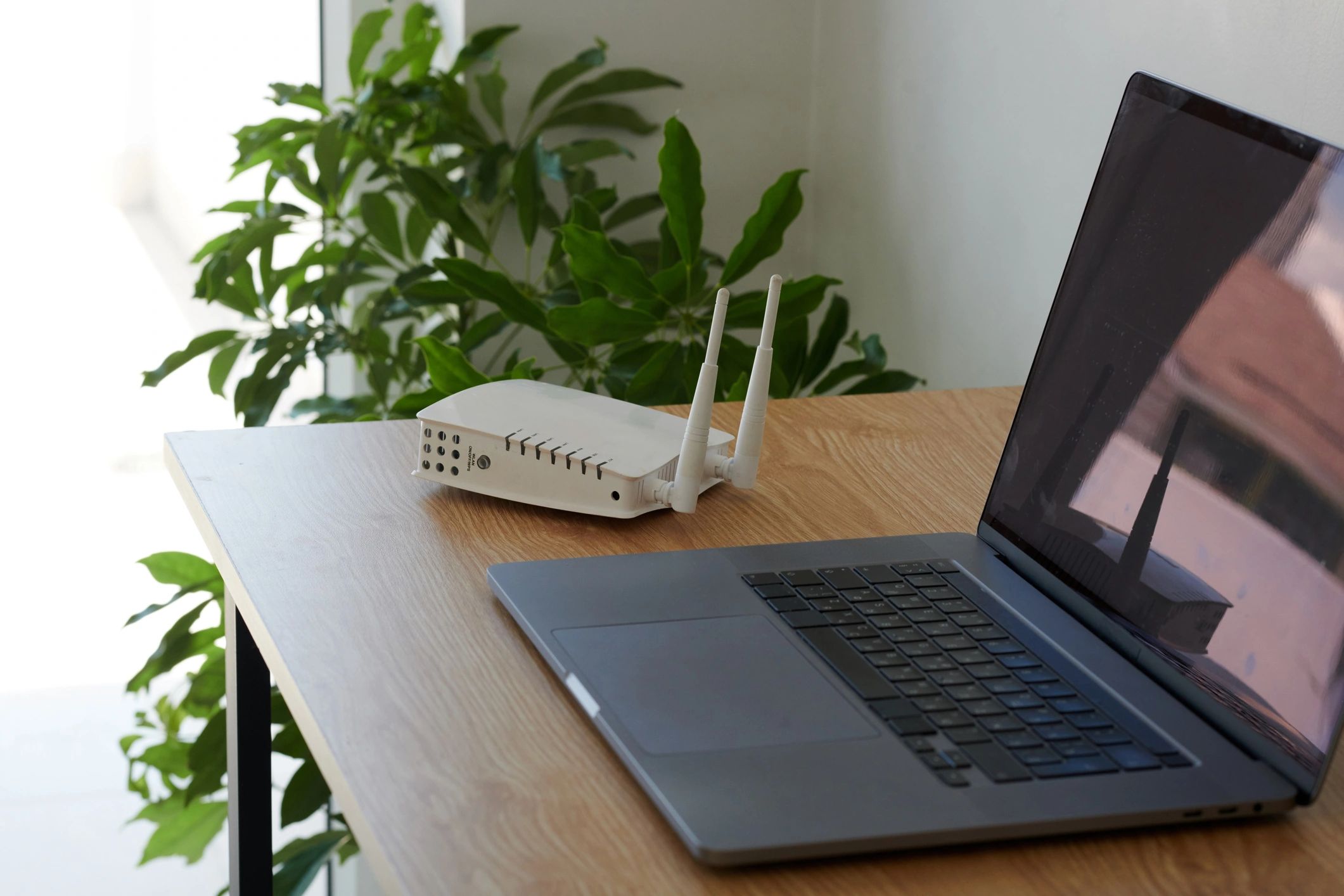 Wi‑Fi router and laptop on a desk