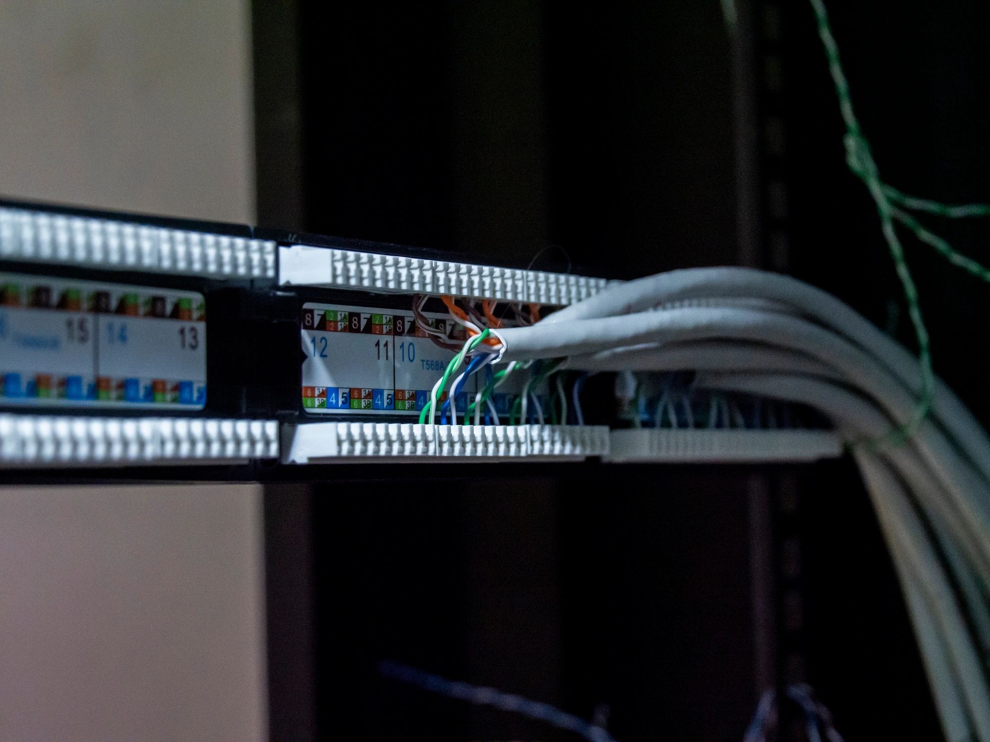 Technician hands installing network cables in a server rack